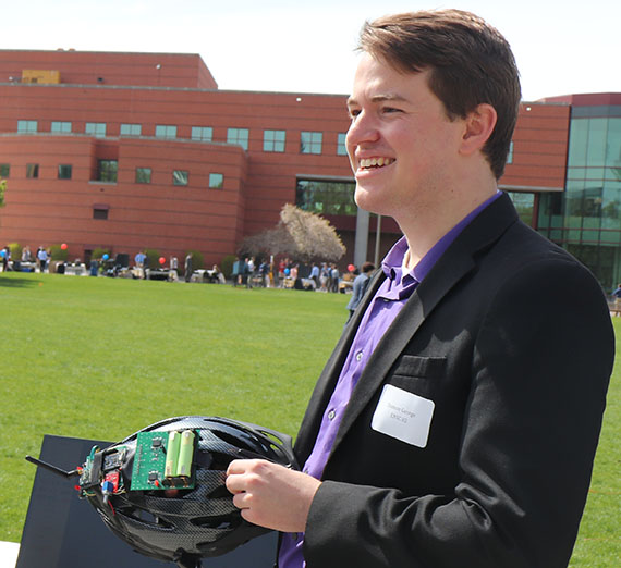 Мужчина опирается на кирпичную стену, за ним — дерево с вишневыми цветами.