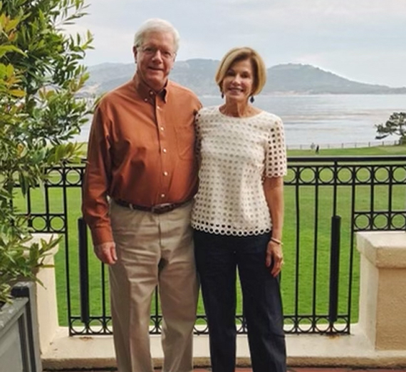 Женщина в выпускном колпаке и мантии улыбается в камеру